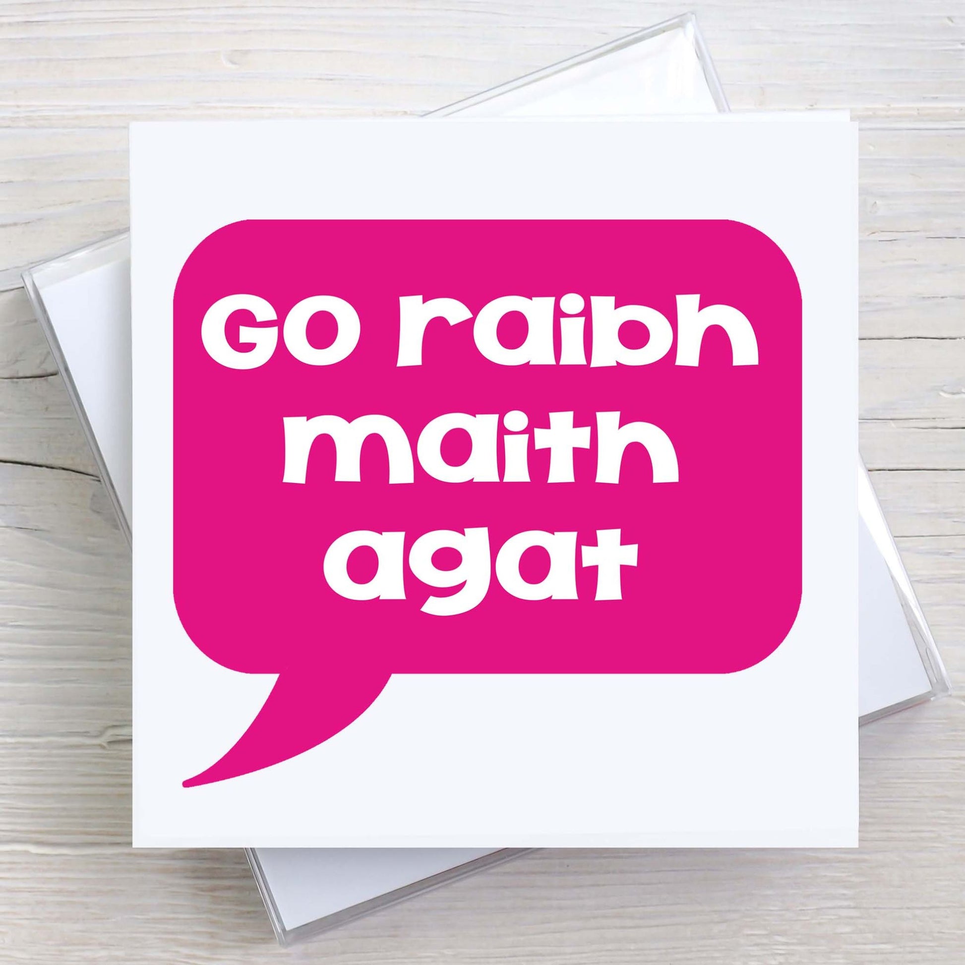 Irish greeting card with words Go Raibh Maith Agat written in a pink speech bubble.  Translates to Thank You, as gaeilge.