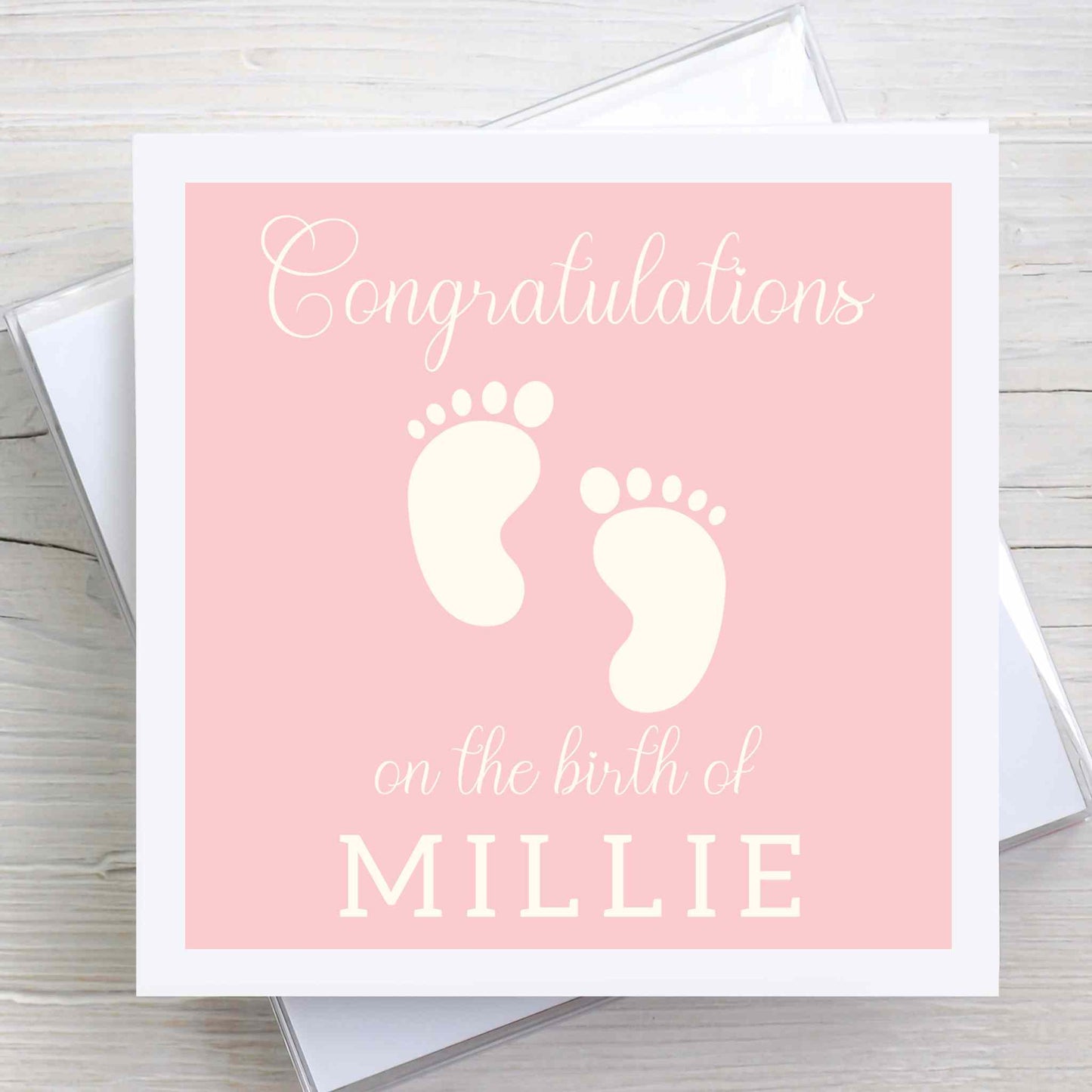 New baby congratulations card featuring baby feet design. Baby name on front. Pink coloured background.